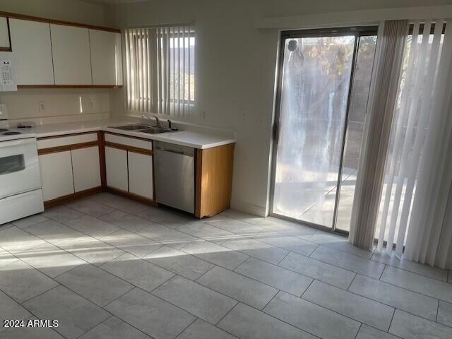 kitchen with white range with electric cooktop, dishwasher, white cabinets, and sink