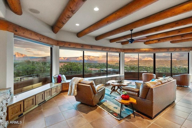 sunroom with ceiling fan, beam ceiling, and a mountain view