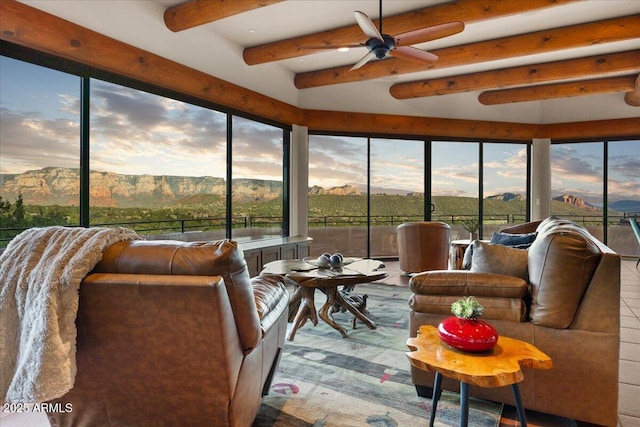 sunroom / solarium with beamed ceiling, ceiling fan, and a mountain view