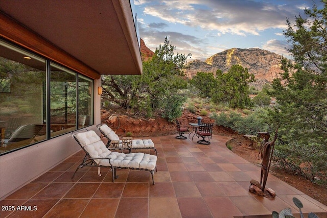 patio terrace at dusk featuring a mountain view