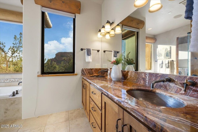 bathroom with vanity, tile patterned flooring, and a relaxing tiled tub