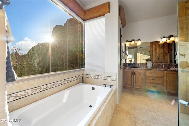 bathroom with tiled bath, tile patterned flooring, and vanity