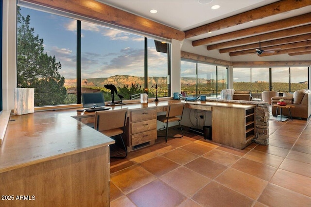 tiled home office featuring a healthy amount of sunlight, beam ceiling, ceiling fan, and a mountain view