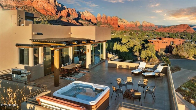 view of patio / terrace featuring a mountain view and an outdoor hot tub