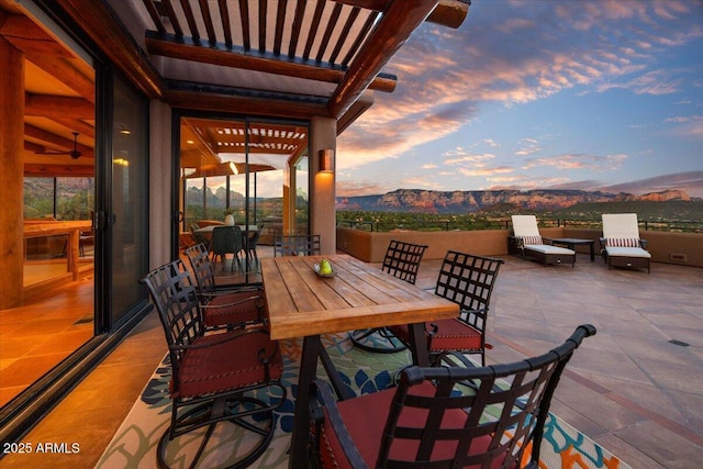 patio terrace at dusk featuring a mountain view