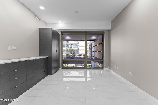 hallway with recessed lighting, marble finish floor, and baseboards