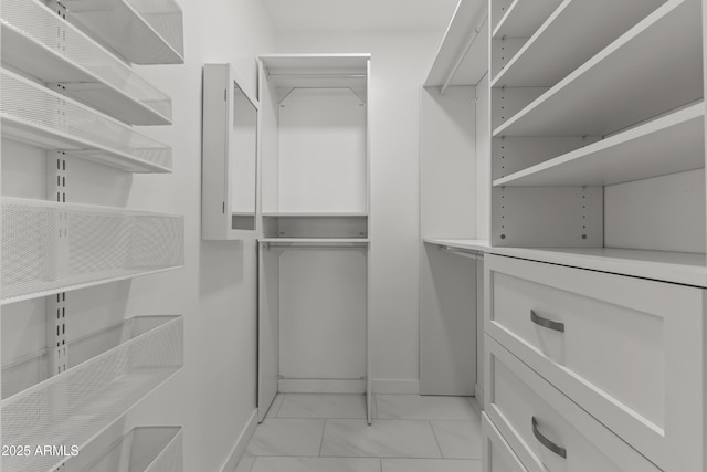 walk in closet with marble finish floor