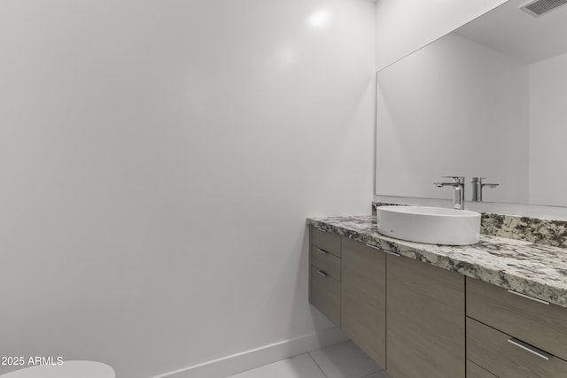 bathroom featuring vanity, baseboards, and visible vents