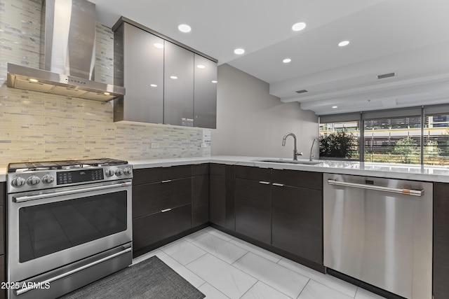 kitchen with visible vents, appliances with stainless steel finishes, modern cabinets, wall chimney exhaust hood, and a sink