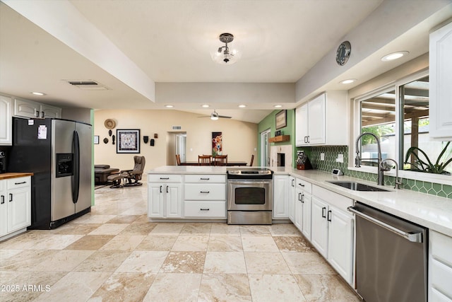 2301 E Sunnyside Dr, Phoenix, AZ 85028 - kitchen with appliances with stainless steel finishes, a sink, a peninsula, tasteful backsplash, and white cabinetry