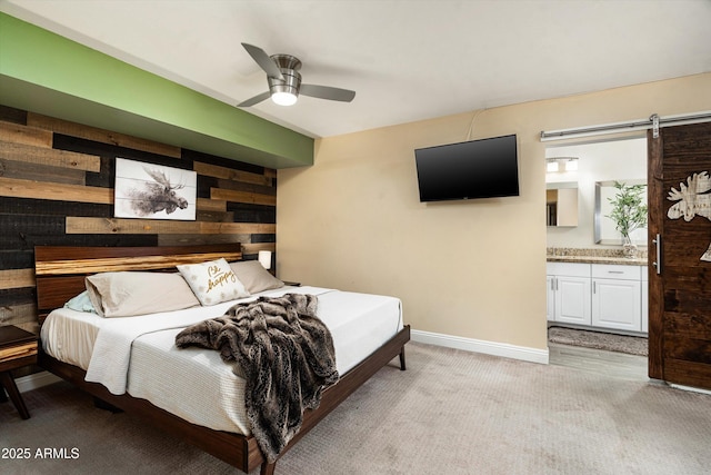 2301 E Sunnyside Dr, Phoenix, AZ 85028 - bedroom with light colored carpet, wooden walls, a barn door, baseboards, and connected bathroom
