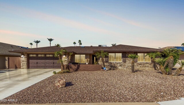 single story home with a garage, concrete driveway, and brick siding