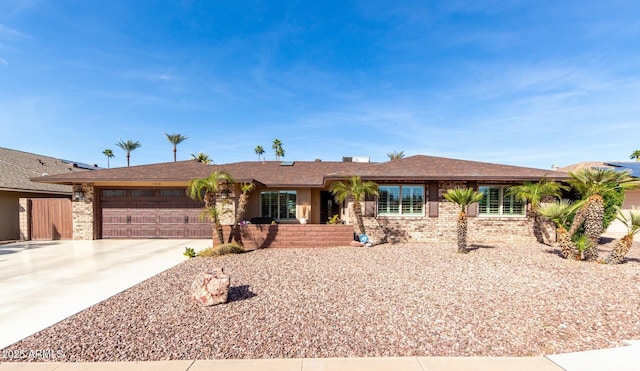 single story home featuring brick siding, driveway, and an attached garage