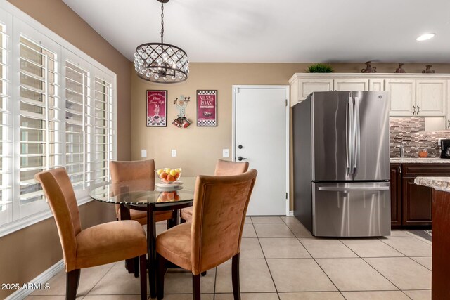 dining area featuring a chandelier and light tile patterned flooring