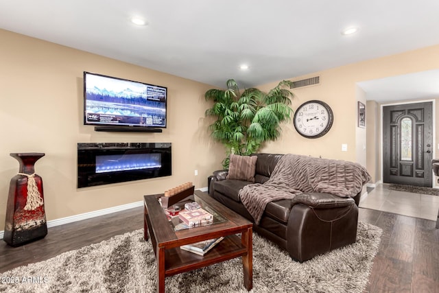 living area featuring recessed lighting, visible vents, baseboards, and wood finished floors