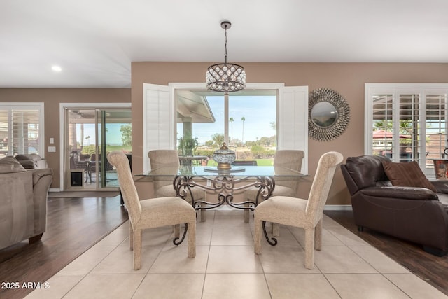 dining area featuring an inviting chandelier, baseboards, and wood finished floors