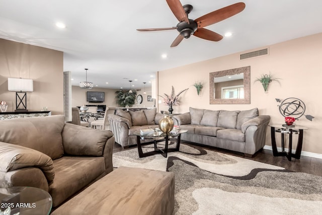 living area with baseboards, wood finished floors, visible vents, and recessed lighting