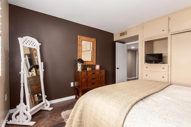 bedroom with baseboards, visible vents, and dark wood finished floors