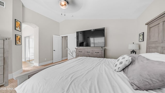 bedroom featuring arched walkways, high vaulted ceiling, carpet, a ceiling fan, and baseboards