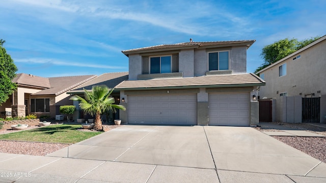 view of front of property with a tiled roof, stucco siding, a garage, driveway, and fence