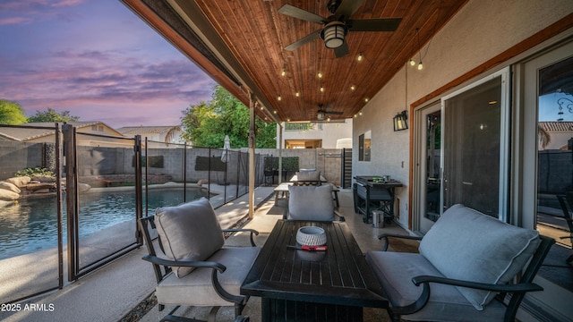 patio terrace at dusk featuring a ceiling fan and a fenced backyard