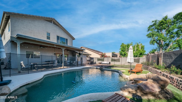view of pool with a ceiling fan, fence, and a patio