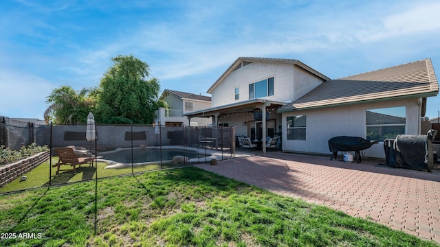 back of house featuring a patio area, stucco siding, and a tiled roof
