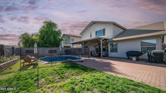back of house featuring stucco siding, a patio, and a tile roof