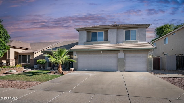view of front of property featuring a tile roof, driveway, stucco siding, a garage, and fence