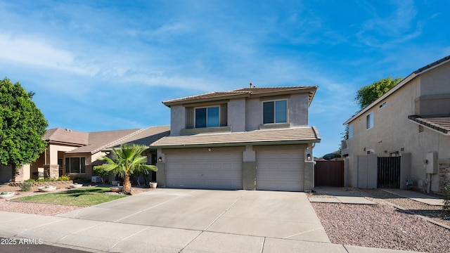 view of front of home featuring a tiled roof, a garage, concrete driveway, stucco siding, and fence