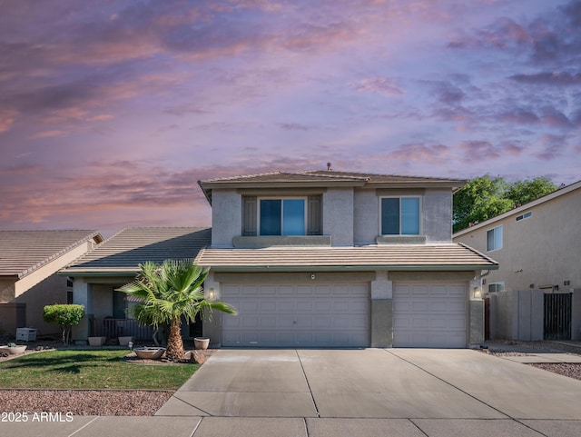 view of front facade with a tiled roof, concrete driveway, a garage, and stucco siding