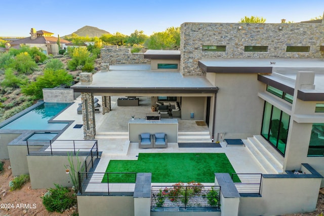 back of house with a mountain view, a yard, a patio, and an outdoor kitchen