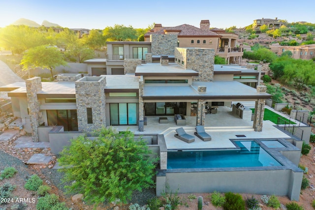 rear view of house with a patio area and a balcony