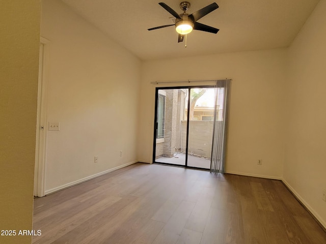 spare room featuring wood finished floors, a ceiling fan, and baseboards