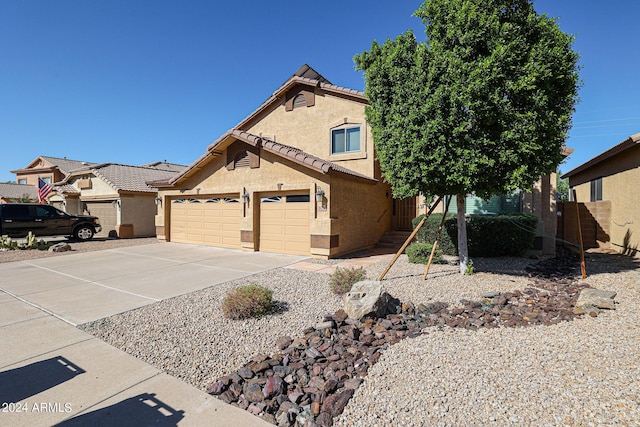 view of front facade featuring stucco siding, an attached garage, driveway, and a tile roof