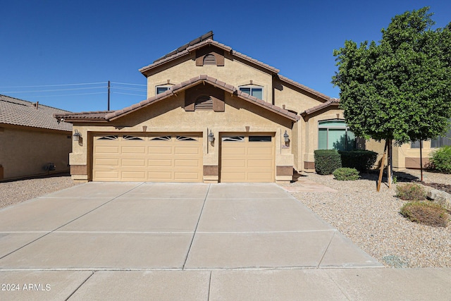 view of front of property featuring a tiled roof, stucco siding, an attached garage, and concrete driveway