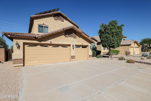 view of side of property with concrete driveway, a tile roof, and stucco siding