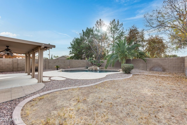 view of yard with a fenced in pool, ceiling fan, and a patio area