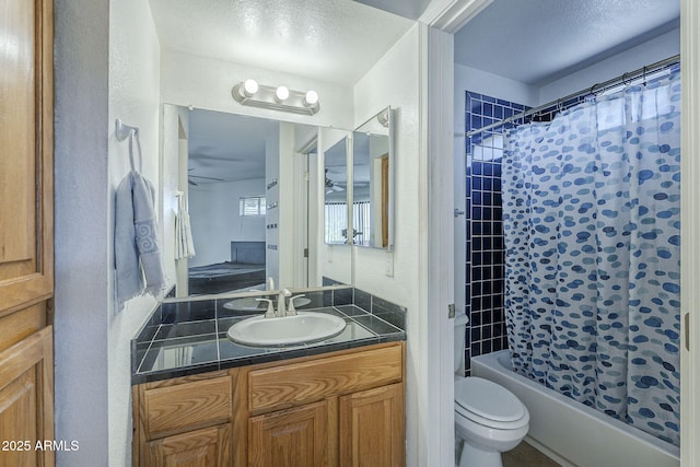 2228 N 52nd St Unit 213, Phoenix, AZ 85008 - bathroom with toilet, shower / tub combo with curtain, vanity, a textured wall, and ceiling fan