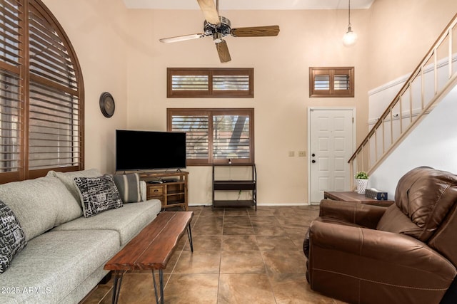 living room with ceiling fan, tile patterned flooring, and a high ceiling