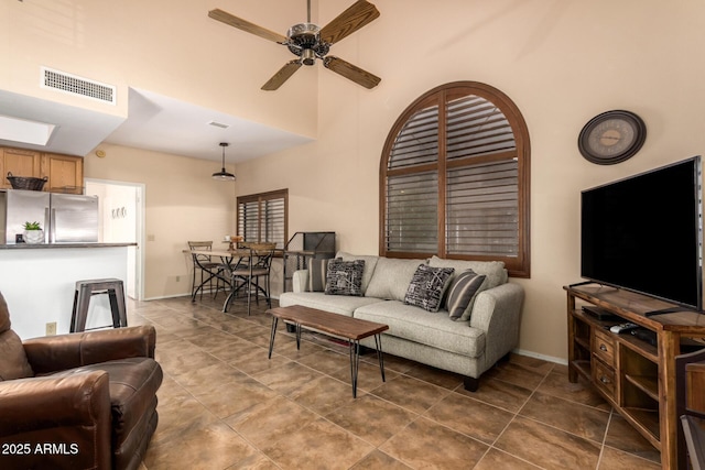 living room with a towering ceiling and ceiling fan