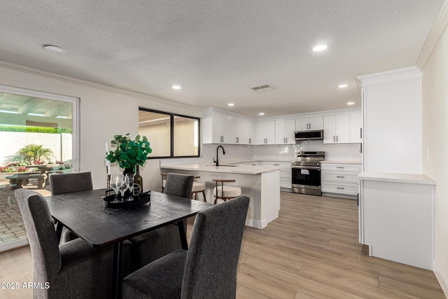 1611 W Palomino Dr, Chandler, AZ 85224 - dining area with a textured ceiling, light wood-style floors, recessed lighting, and ornamental molding