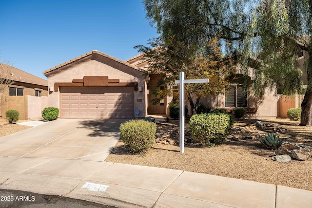 view of front of house with a garage, driveway, a tile roof, and stucco siding