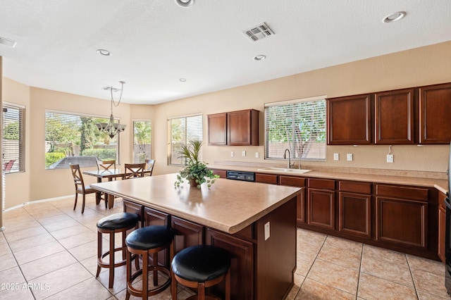 kitchen with visible vents, a sink, a breakfast bar area, and light tile patterned floors