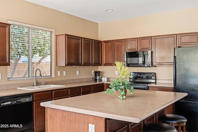 kitchen featuring black appliances, a kitchen island, a sink, and light countertops