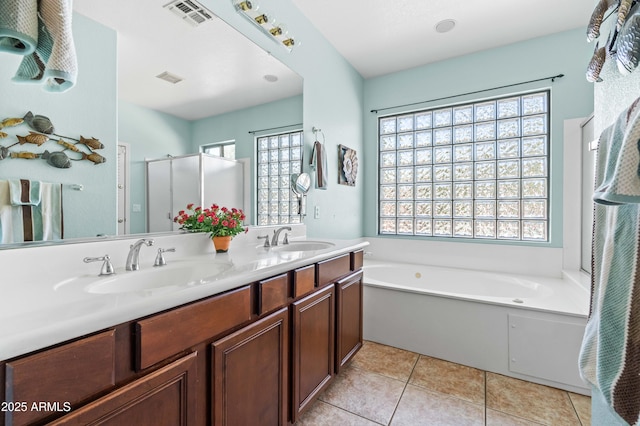 full bath with visible vents, a sink, a shower stall, and tile patterned floors