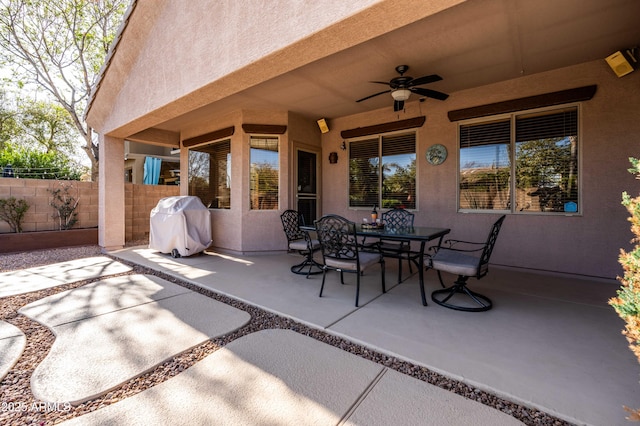 view of patio with fence, grilling area, a ceiling fan, and outdoor dining space