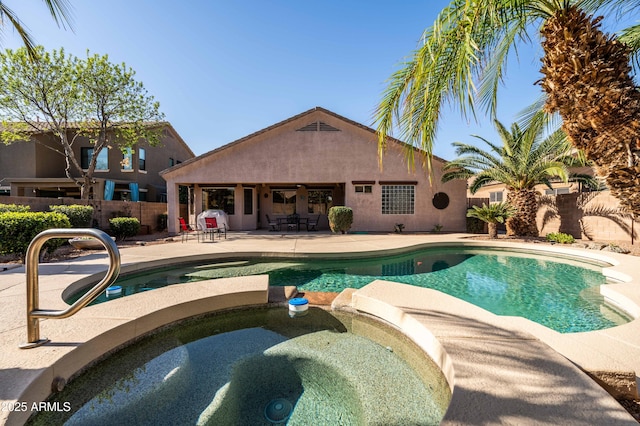 view of swimming pool with a grill, a pool with connected hot tub, a fenced backyard, and a patio