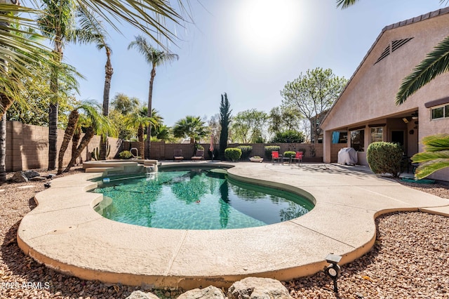 view of swimming pool with a pool with connected hot tub, a patio area, and a fenced backyard