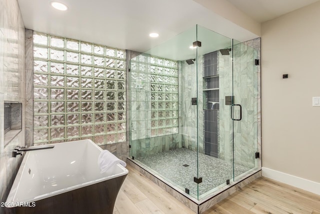 bathroom featuring a soaking tub, recessed lighting, a shower stall, and wood finished floors